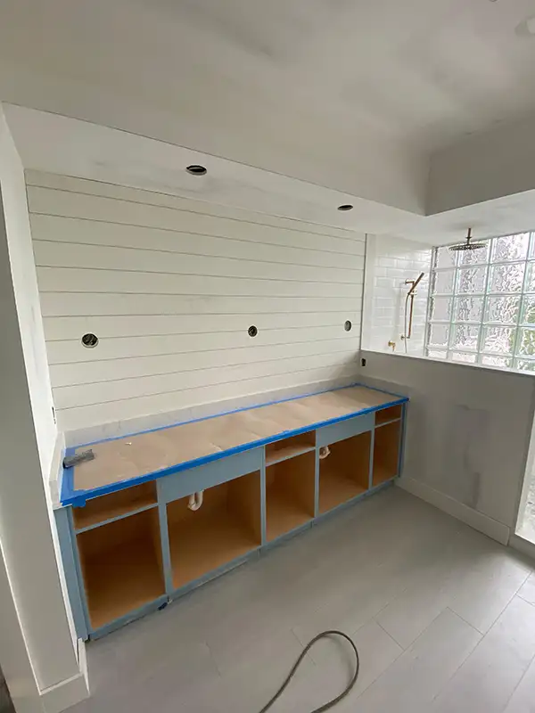 Shiplap wall and built-in cabinets being installed