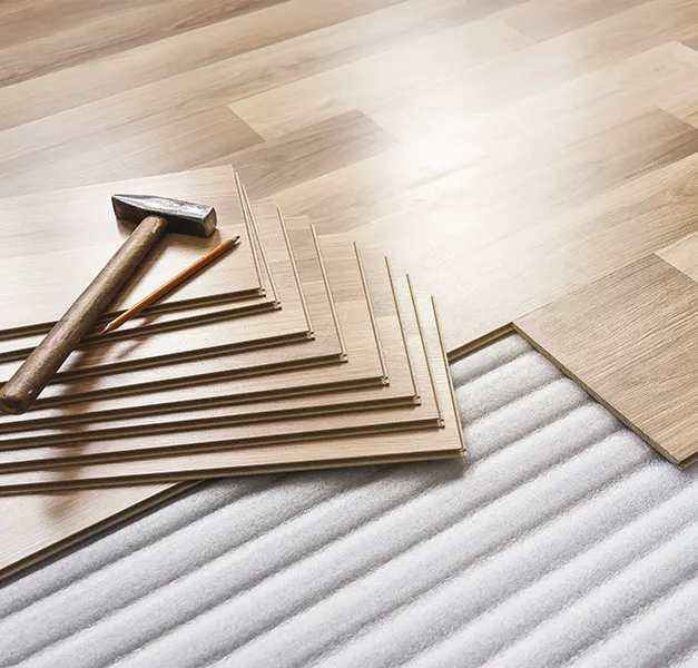 Flooring installation with hammer and laminate planks